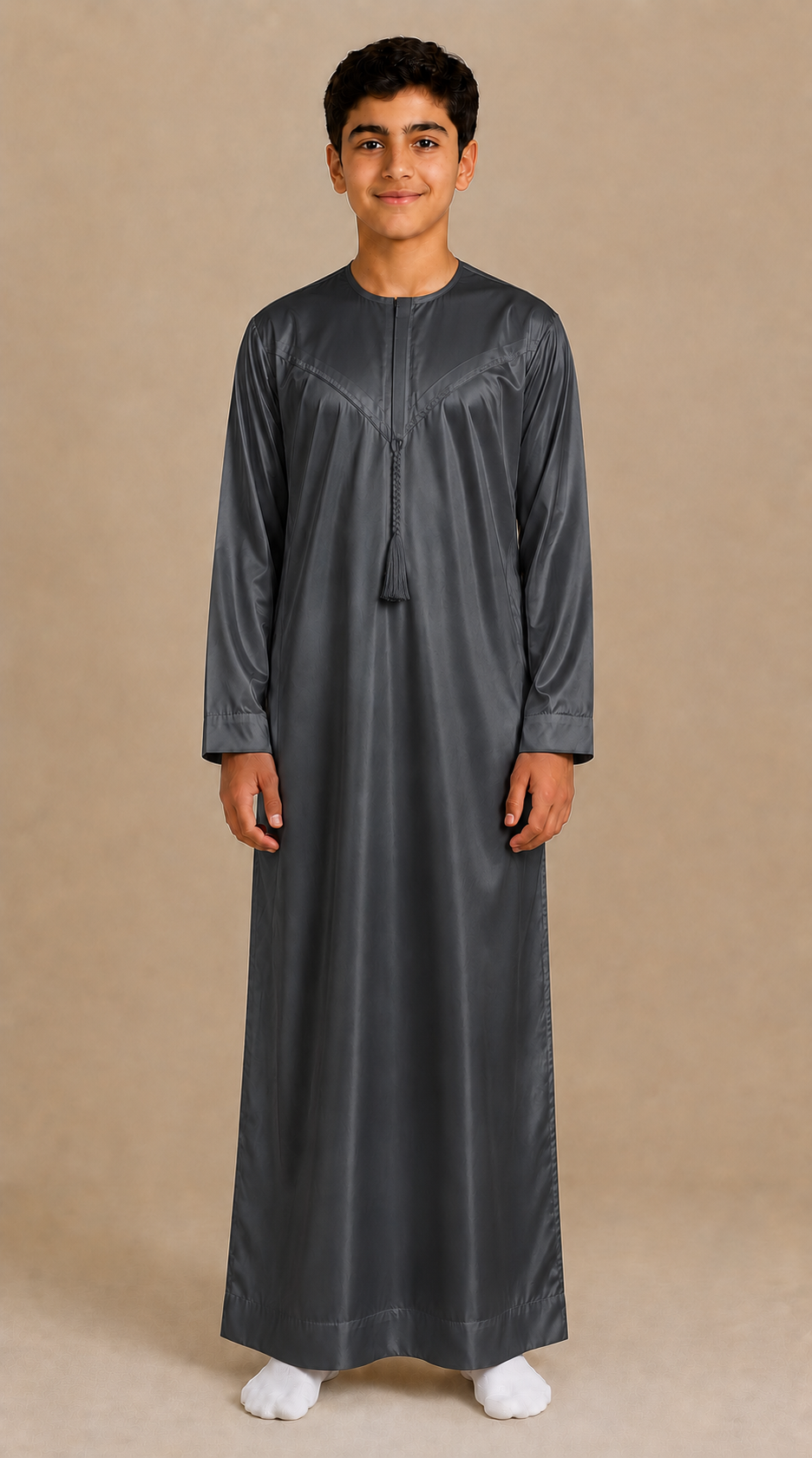 Boy wearing dark grey shiny jubba with removable tassel